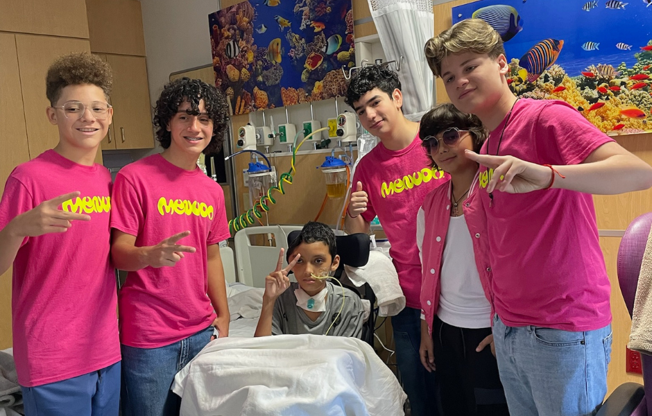 Menudo poses with patient in hospital room.