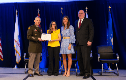 Katy Epley accepts the Fisher Service Award on stage