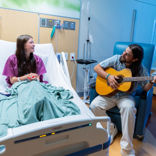 Noah Kahan plays for a hospital patient